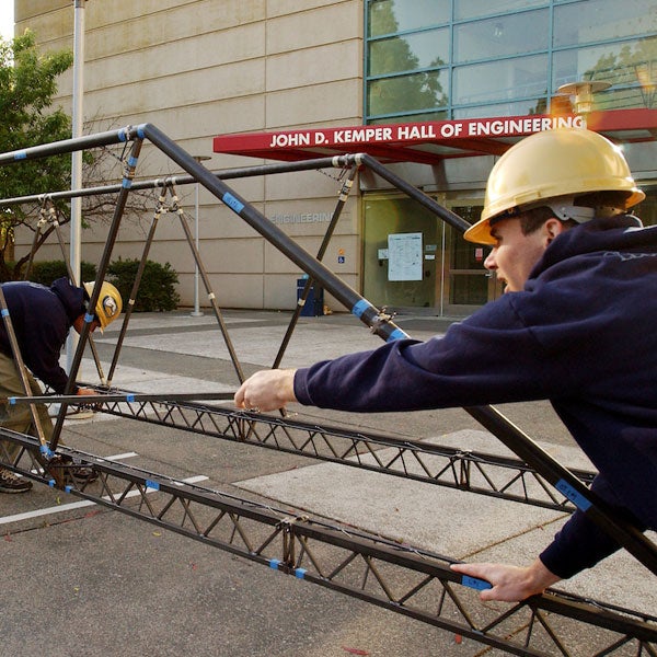 Students build an iron bridge outside of the Engineering complex at ֱ