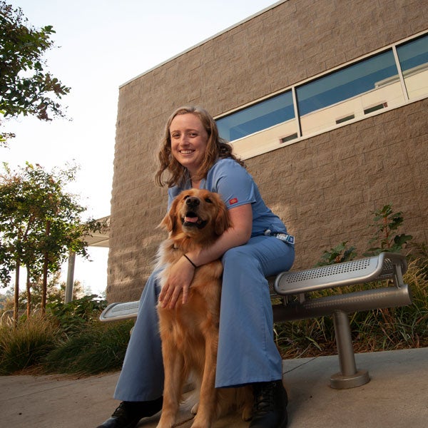 A veterinary student cares for a dog outside of the ֱ School of Veterinary Medicine