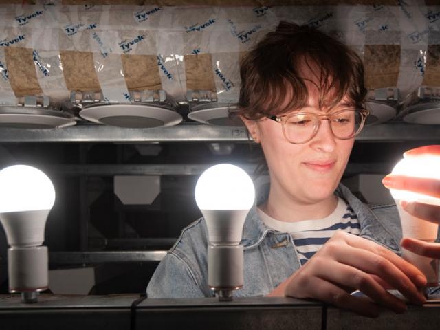 A female ֱ researchers examines some new lighting technology