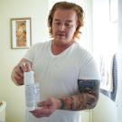 Matthew Treviño holds a canister of a hormonal birth control gel for men while in his home in Sacramento. He is part of a clinical trial at ֱ Health testing the new drug. 