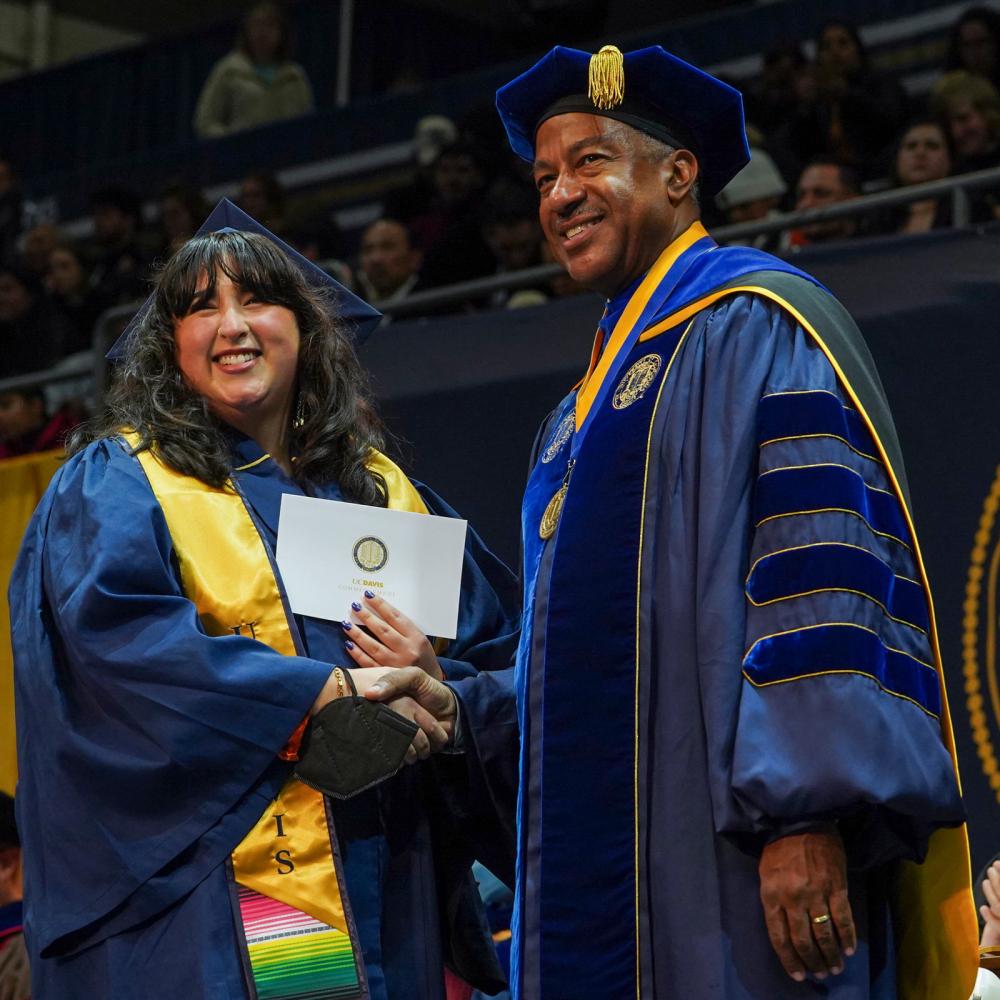 A ֱ student shakes Chancellor May's hand at commencement